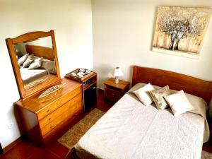 1 dormitorio con cama y espejo grande en Ninho das Cagarras, en Santo Amaro