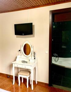 La salle de bains est pourvue d'une coiffeuse blanche, d'un miroir et d'une baignoire. dans l'établissement Ninho das Cagarras, à Santo Amaro