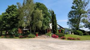 una casa con alberi e fiori nel vialetto di Camping Au Tour de l'Aveyron a LʼHospitalet-du-Larzac