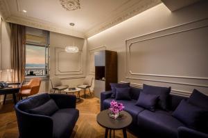 a living room with a couch and a table with purple pillows at Hotel Ambasador - Liburnia in Opatija