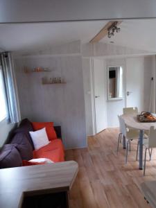 een woonkamer met een bank en een tafel bij Luxueuze stacaravan 4pers met terras en tuintje Bredene (2010) in Bredene