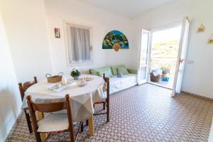 uma sala de jantar com uma mesa e um sofá em Casa Silvia em Marina di Campo
