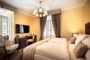 a bedroom with a bed and a desk and a television at Villa Abbazia - by Liburnia Hotels & Villas in Opatija