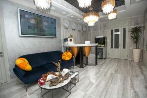 Hotel "Mandarin Clubhouse" في خاركوف: غرفة معيشة مع أريكة زرقاء وطاولة