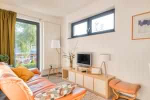 uma sala de estar com um sofá e uma televisão em Ferienwohnung Grünes Berlin em Berlim