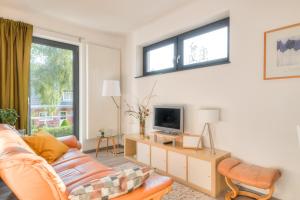 ein Wohnzimmer mit einem Sofa und einem TV in der Unterkunft Ferienwohnung Grünes Berlin in Berlin