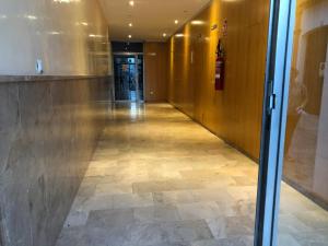 a hallway in a building with a tile floor at Apartamento Sorolla Center in Ayamonte