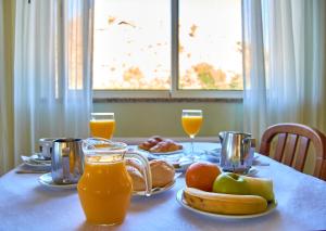 stół z sokiem pomarańczowym i owocami w obiekcie Hotel Miracastro w mieście Castro Laboreiro