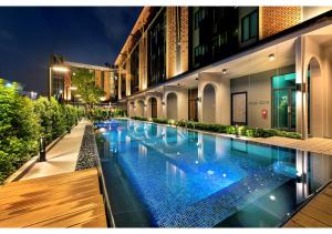 a swimming pool in the middle of a building at PLAAI Plus Hotel Rayong in Rayong