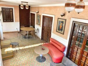 uma sala de estar com um sofá vermelho e uma mesa em Riad Rockech em Marrakech