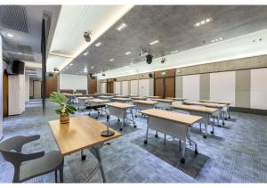 une salle de classe avec des bureaux et des chaises dans une salle dans l'établissement PLAAI Plus Hotel Rayong, à Rayong