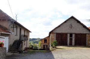 um antigo edifício de pedra ao lado de um edifício com uma escadaria em Les Hauts de Malirat em Capdenac-Gare