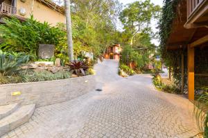 a cobblestone street in a resort with trees and plants at Dubai Bungalows Bombinhas in Bombinhas