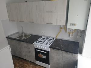 a small kitchen with a stove and a sink at Apartament in chirie Moldova or.Soroca in Soroca