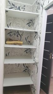 a closet with white shelves and a patterned wall at Apartament in chirie Moldova or.Soroca in Soroca