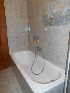 加爾達湖濱的住宿－Casa Family Riva del Garda，瓷砖浴室内设有带软管的浴缸