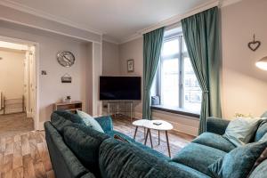 a living room with a blue couch and a window at The Rooftop in Buxton