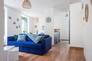 un divano blu in un soggiorno con pareti bianche di My Colmar Homes - Le XIII a Colmar