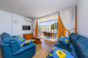 a living room with two blue couches and a table at Casa Laura in Cala Ratjada