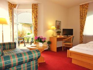um quarto de hotel com uma cama e uma secretária em Landhaus Müritzgarten Hotel garni em Röbel