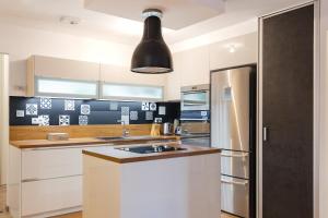 cocina con nevera de acero inoxidable y luz negra en My Colmar Homes - Colmar Rempart, en Colmar