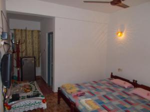Un dormitorio con una cama y un ventilador de techo. en Arjun Villa Guest House, en Anjuna