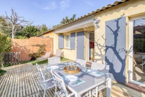 a patio with a table and chairs on a deck at Primavéra in Sanary-sur-Mer