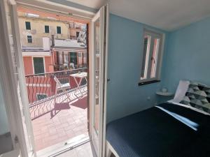 a bedroom with a bed and a balcony at SeaBreeze Vernazza in Vernazza