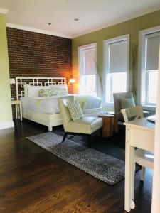 Schlafzimmer mit einem Bett, einem Schreibtisch und Stühlen in der Unterkunft Suites at 249 in Culpeper