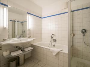 a bathroom with a sink and a tub and a shower at Kaiservillen Heringsdorf - Ferienwohnung mit 1 Schlafzimmer und Balkon D112 in Heringsdorf