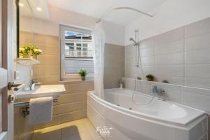 a white bathroom with a tub and a sink at Havlyst in Olpenitz