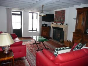 a living room with red couches and a fireplace at Gite Des Vignes in Verdigny