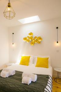 リスボンにあるAlfama Terrace River View 12 by Lisbonne Collectionのベッドルーム1室(黄色い枕とタオル付きのベッド1台付)