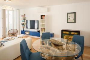 リスボンにあるCentral Apartment with Parking, Terrace and swimming pool 56 by Lisbonne Collectionのリビングルーム(ガラステーブル、青い椅子付)