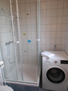 a shower and a washing machine in a bathroom at Ferienhaus Weitblick in Emden
