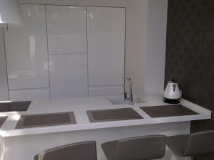a kitchen with a counter with a sink and chairs at Central Apartment Palanga in Palanga