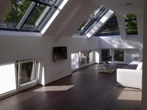 a living room with skylights and a couch and a tv at Central Apartment Palanga in Palanga