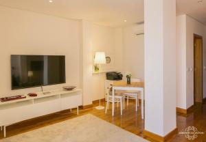 ein Wohnzimmer mit einem TV und einem Tisch mit Stühlen in der Unterkunft Modern and Comfort Apartment 25 by Lisbonne Collection in Lissabon