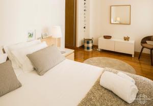 ein weißes Schlafzimmer mit einem großen weißen Bett und einem Spiegel in der Unterkunft Modern and Comfort Apartment 25 by Lisbonne Collection in Lissabon
