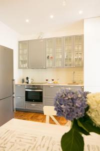 una cocina con electrodomésticos de acero inoxidable y un jarrón de flores en Classic and Super Central Apartment 20 by Lisbonne Collection, en Lisboa