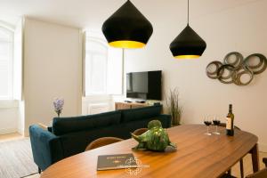 a living room with a green couch and a wooden table at Downtown Stylish by the River 66 by Lisbonne Collection in Lisbon