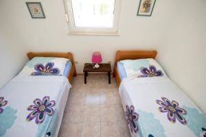two twin beds in a room with a table at Apartment in Duce with sea view, balcony, air conditioning, Wi-Fi (132-3) in Duće