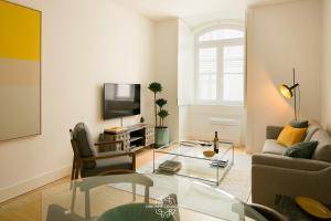 uma sala de estar com um sofá e uma televisão em Downtown Sleek Apartment 65 by Lisbonne Collection em Lisboa