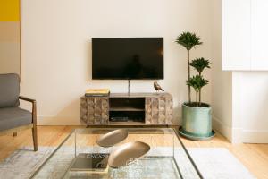 a living room with a tv and a glass table at Downtown Sleek Apartment 65 by Lisbonne Collection in Lisbon