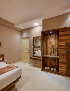 - une chambre avec un lit et un miroir dans l'établissement Sanctum Luxury Serviced Apartments, à Chikmagalur
