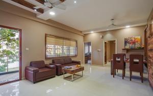 - un salon avec un canapé et une table dans l'établissement Sanctum Luxury Serviced Apartments, à Chikmagalur