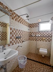 La salle de bains est pourvue d'un lavabo et de toilettes. dans l'établissement Sanctum Luxury Serviced Apartments, à Chikmagalur