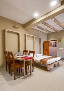 a bedroom with a dining room table and a bed at Sanctum Luxury Serviced Apartments in Chikmagalūr +3 photos