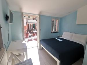 a blue bedroom with a bed and a balcony at SeaBreeze Vernazza in Vernazza