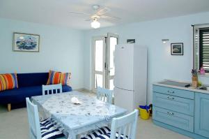 een keuken met een tafel en een witte koelkast bij Beachfront Apartment in Tri Porte, with sea view, terrace, air conditioning, WiFi 5208-2 in Potirna